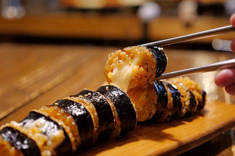 チーズキンパを箸で持ち上げている