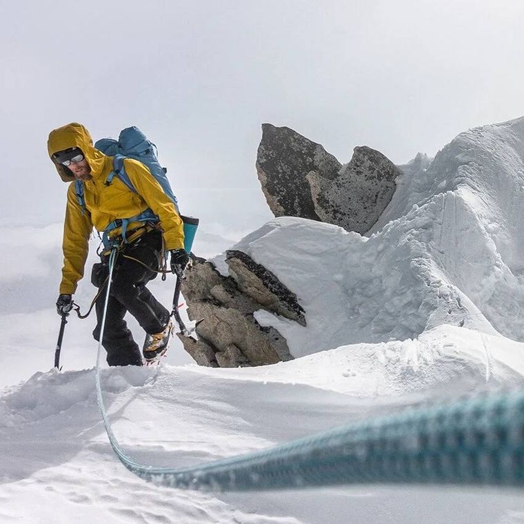 男性が雪山を登っている