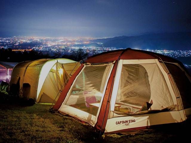 街の夜景を背景にテントが設営されている