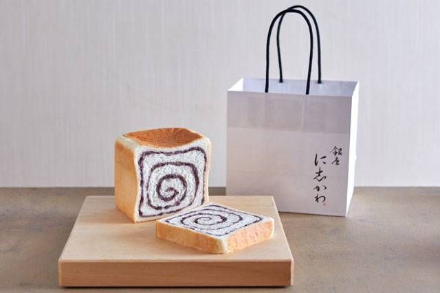 粒あんが練り込まれた食パンと手提げの紙袋が置かれている