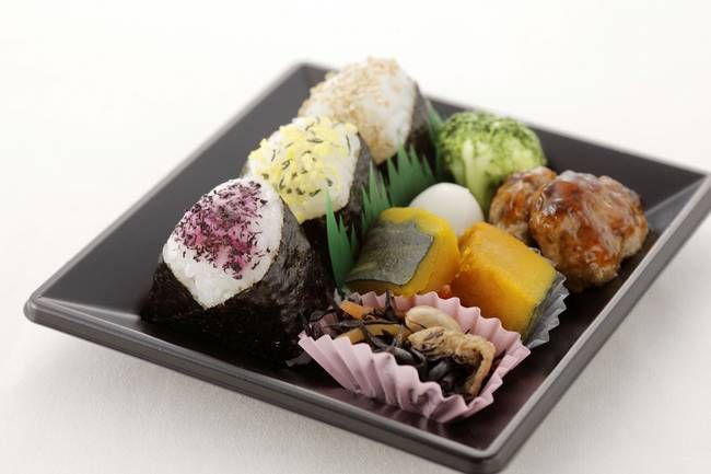 おにぎりやかぼちゃの煮物などが入ったお弁当