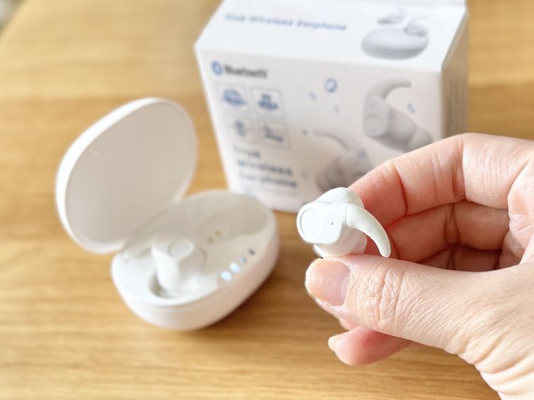 片手で持っているTWS004のイヤホンとケースやパッケージ