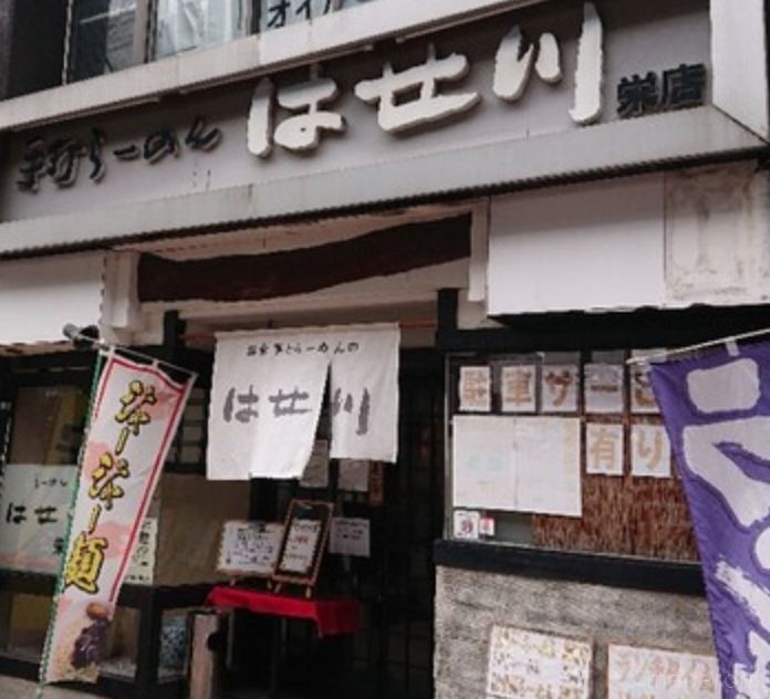 黒文字で屋号が入った白い暖簾 ジャージャー麺ののぼり