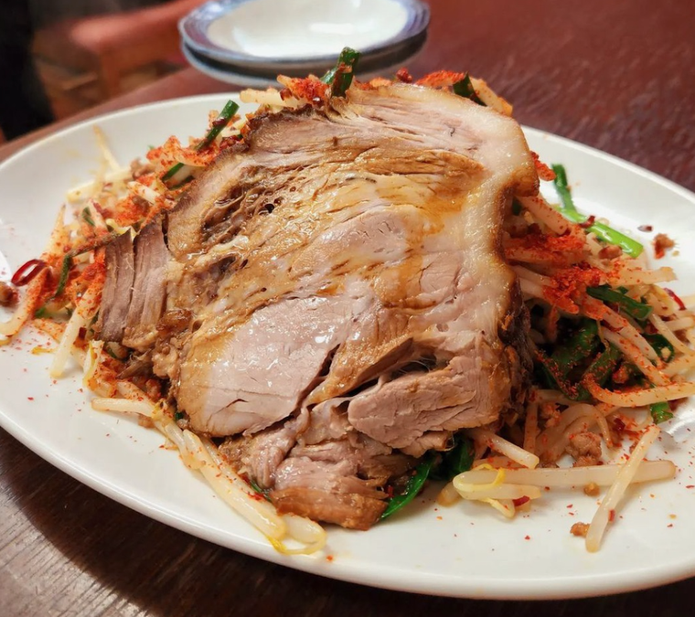 白いお皿にチャーシューと麺、ニラ、ミンチ、もやしが混ざり合った皿台湾