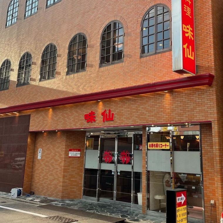 茶色い壁と赤文字で壁に書かれた屋号 自動ドア