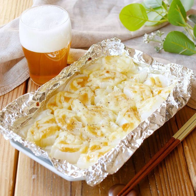 新玉ねぎのみそマヨチーズ焼きとビールが置かれている