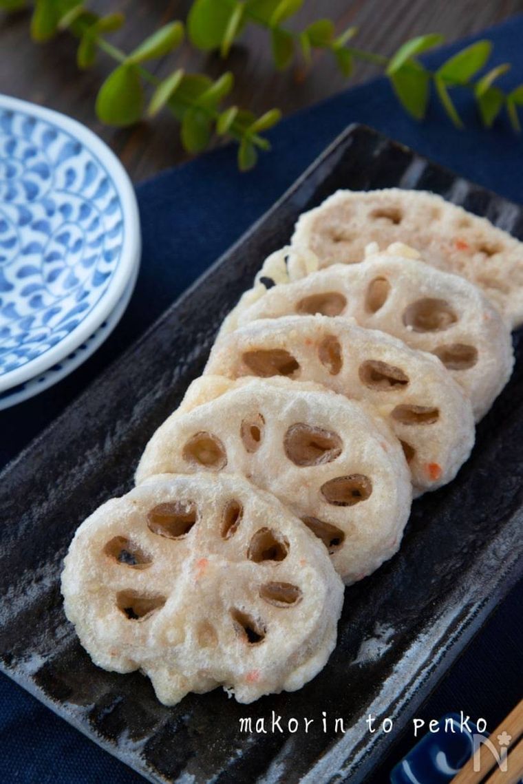 黒の皿にれんこんの天ぷらがのっている様子