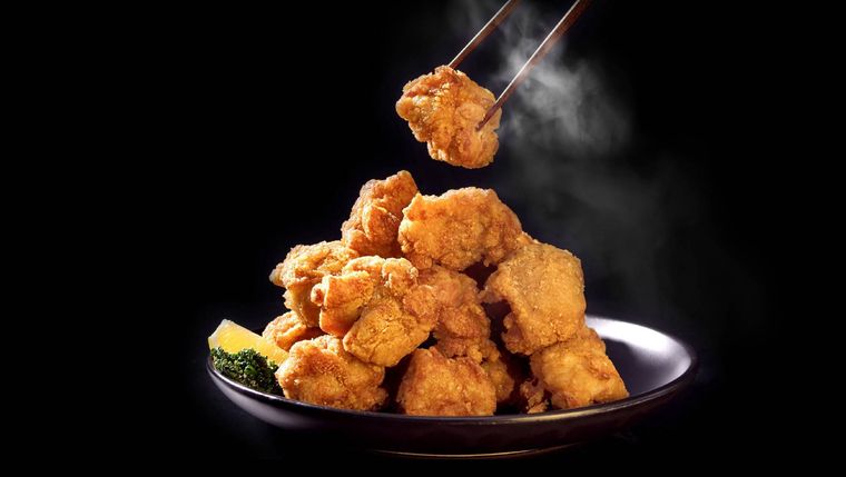 箸で唐揚げを持ち上げている