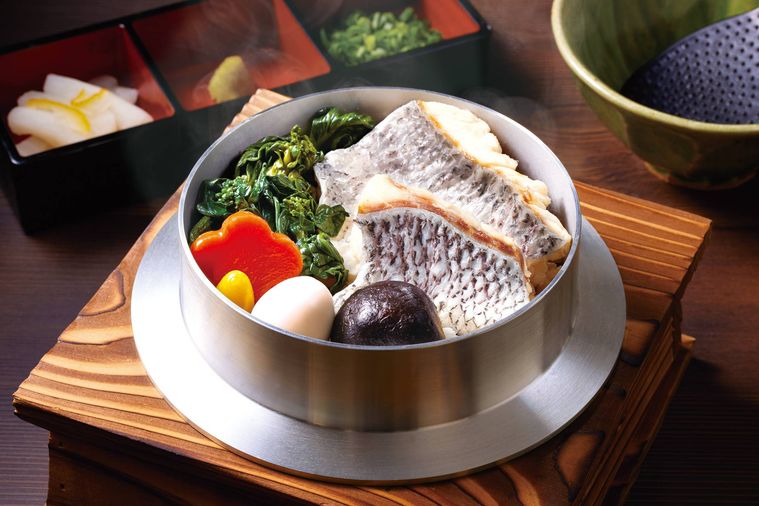 鯛の切り身、菜の花、にんじんなどがのった釜飯