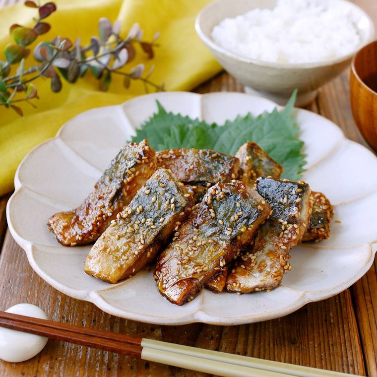 白い花型の皿に盛り付けたさばのごま照り焼き