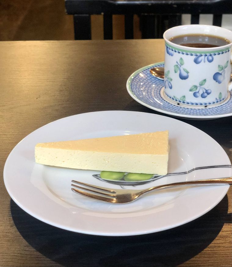 鋭角にカットされたレアチーズケーキとコーヒーのセット
