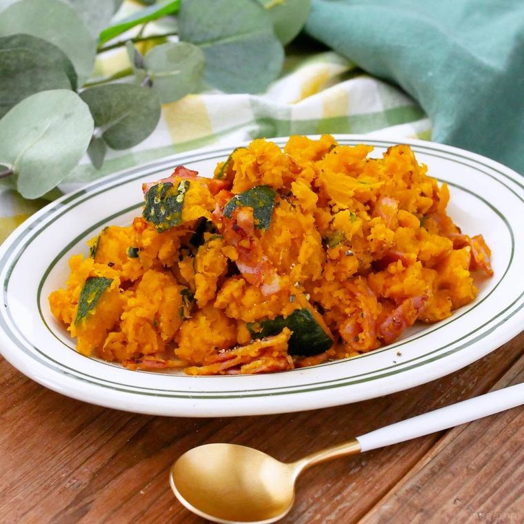 緑色の縁取りの白色の皿に盛られたかぼちゃとベーコンのシンプルサラダ