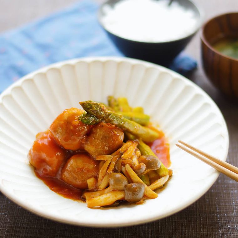 皿に盛られた豚肉巻き麩とアスパラのチリソース煮
