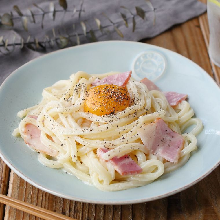 混ぜて完成したカルボナーラうどんが皿に入っているところ