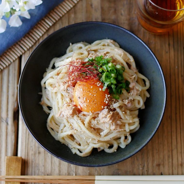 ツナマヨたれうどんが青い皿に盛り付けられているところ
