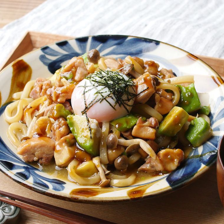 鶏肉とアボカドの甘辛うどんが和風の皿に入っているところ