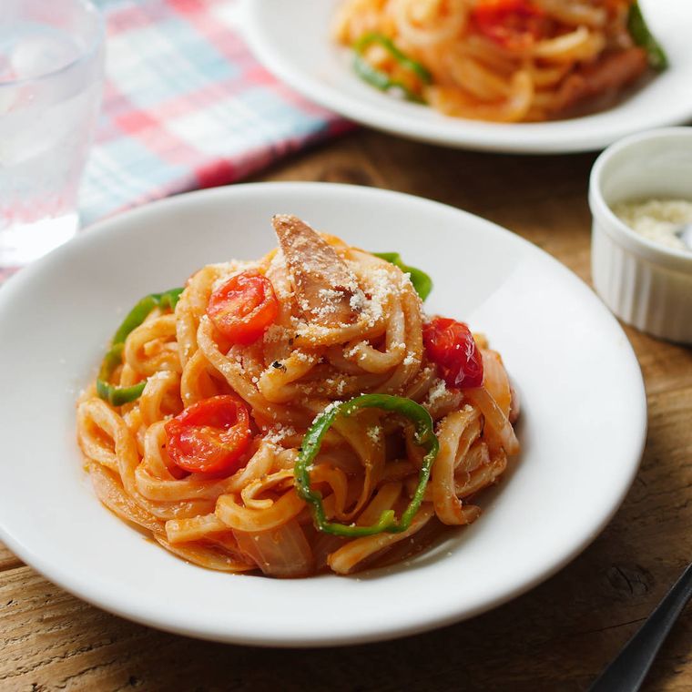 冷やしナポリタンうどんが白い皿に盛り付けられているところ
