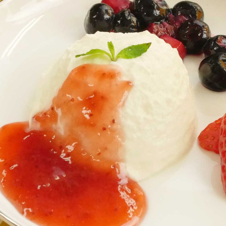 白いお皿に盛られた水切りヨーグルトクレームダンジュにソースをかけたもの