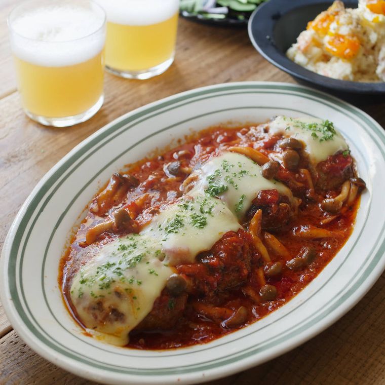 オパール皿に盛り付けられているトマト煮込みチーズハンバーグ