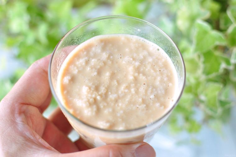 フローズンミルクティーが入ったグラスを手で持ち上げている様子