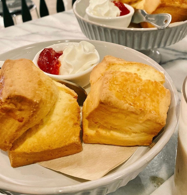皿にもられた2つの四角いスコーンとクリームとジャム