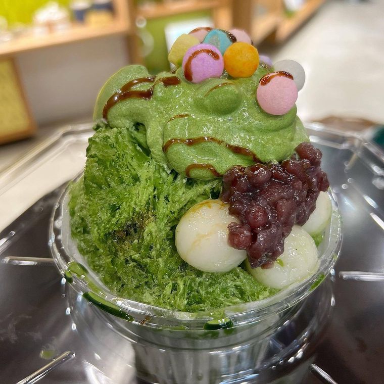 抹茶くりーむかき氷においりや白玉などをトッピングしている様子