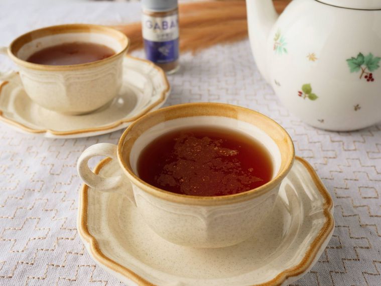 シナモンティーが入ったティーカップふたつとティーポット、シナモンパウダー