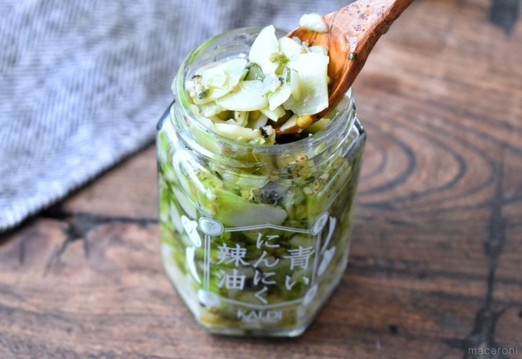 カルディの青いにんにく辣油がスプーンですくわれている