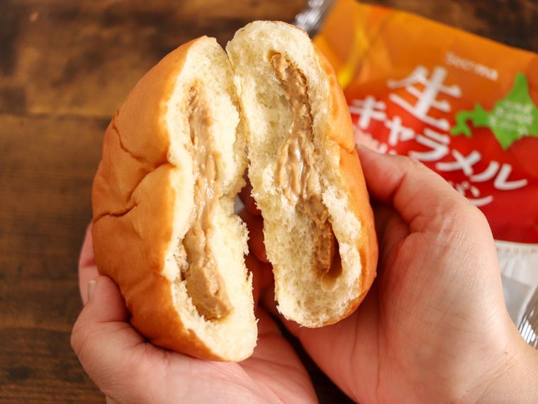 半分に割ったセイコーマートの生キャラメルクリームパンを手で持っている
