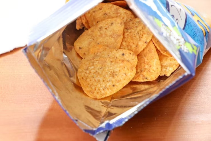 鮭とばコーンチップスの袋を開けて中身を覗いている様子