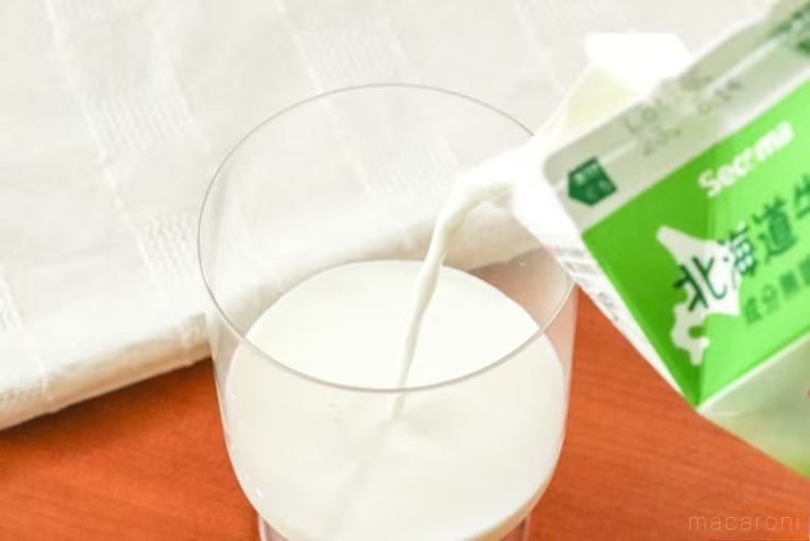 透明のグラスに北海道牛乳を注いでいる様子
