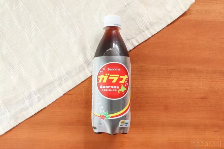 白いランチョンマットを斜めに敷いた木製のテーブルの上に置かれたガラナ