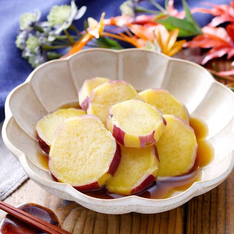 白色の花型の皿に盛られたさつまいもの煮物