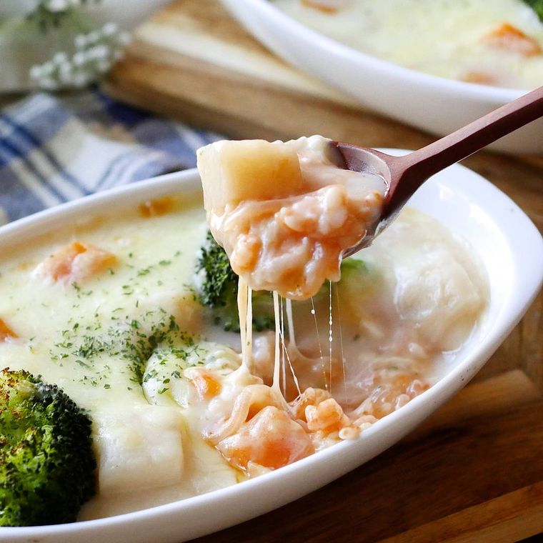 白い耐熱容器に入っているドリアをスプーンですくった様子