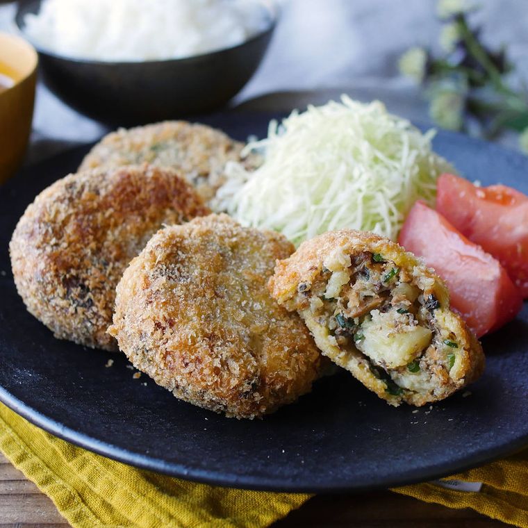 紺色の皿に盛りつけられたさば味噌煮缶コロッケとつけ合わせ