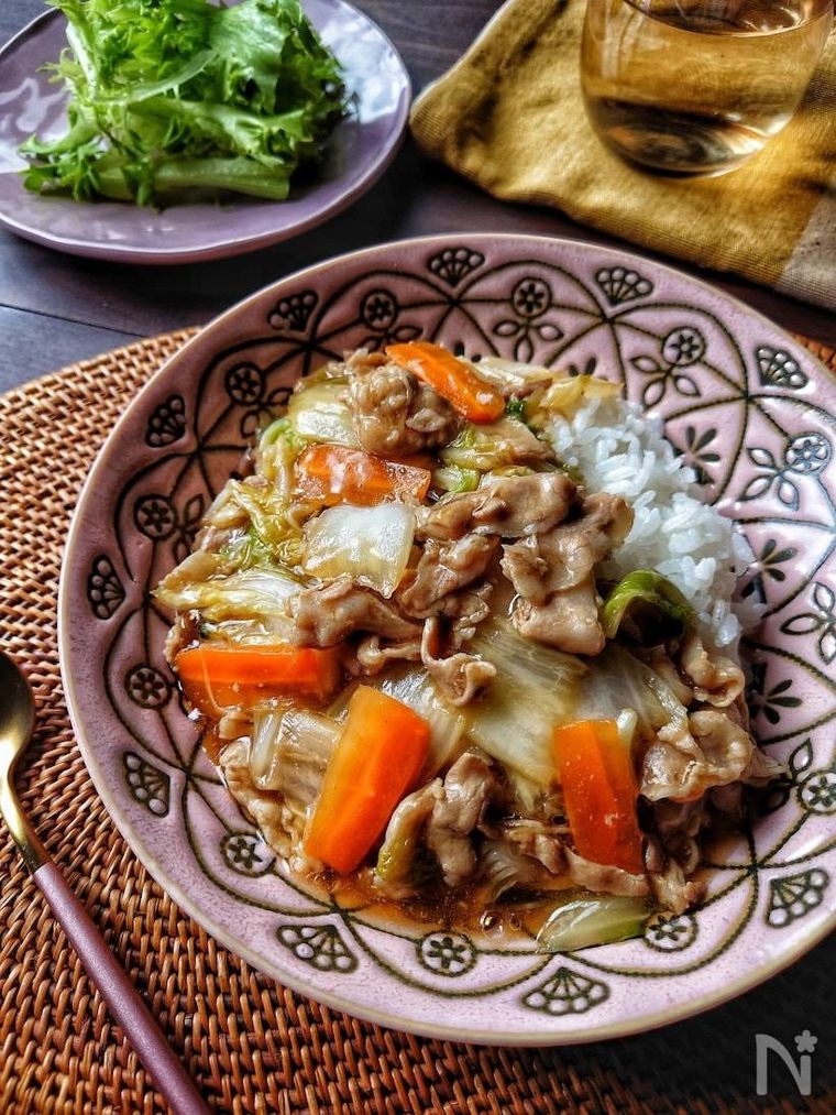 ピンクの皿に盛られた新しょうがと豚バラの中華丼