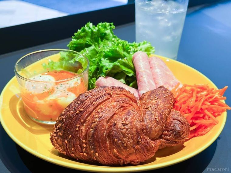 黄色い皿にクロワッサンやハム、サラダ、エッグスラットが盛られたCBエッグスラットブレックファースト