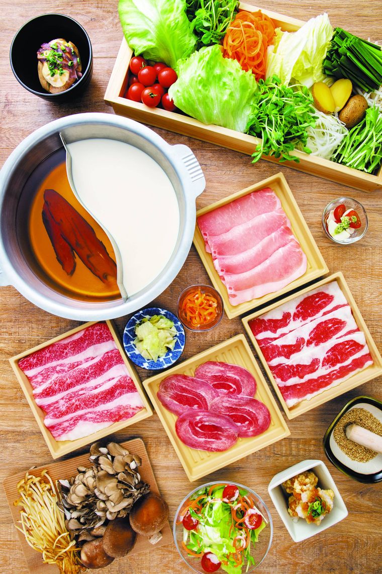 テーブルの上にしゃぶしゃぶ用の肉や野菜が並べられている