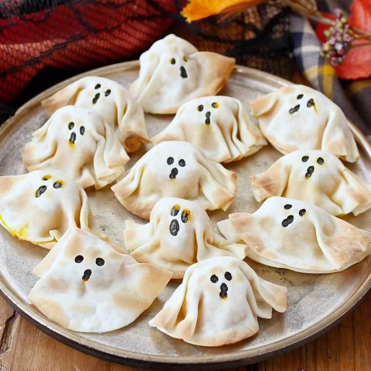 おばけの顔がついている餃子が皿にたくさん並んでいるところ