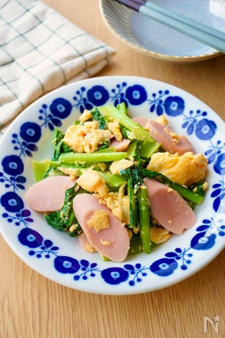 白地に青い花が描かれた器に盛られた小松菜と魚肉ソーセージの卵炒め