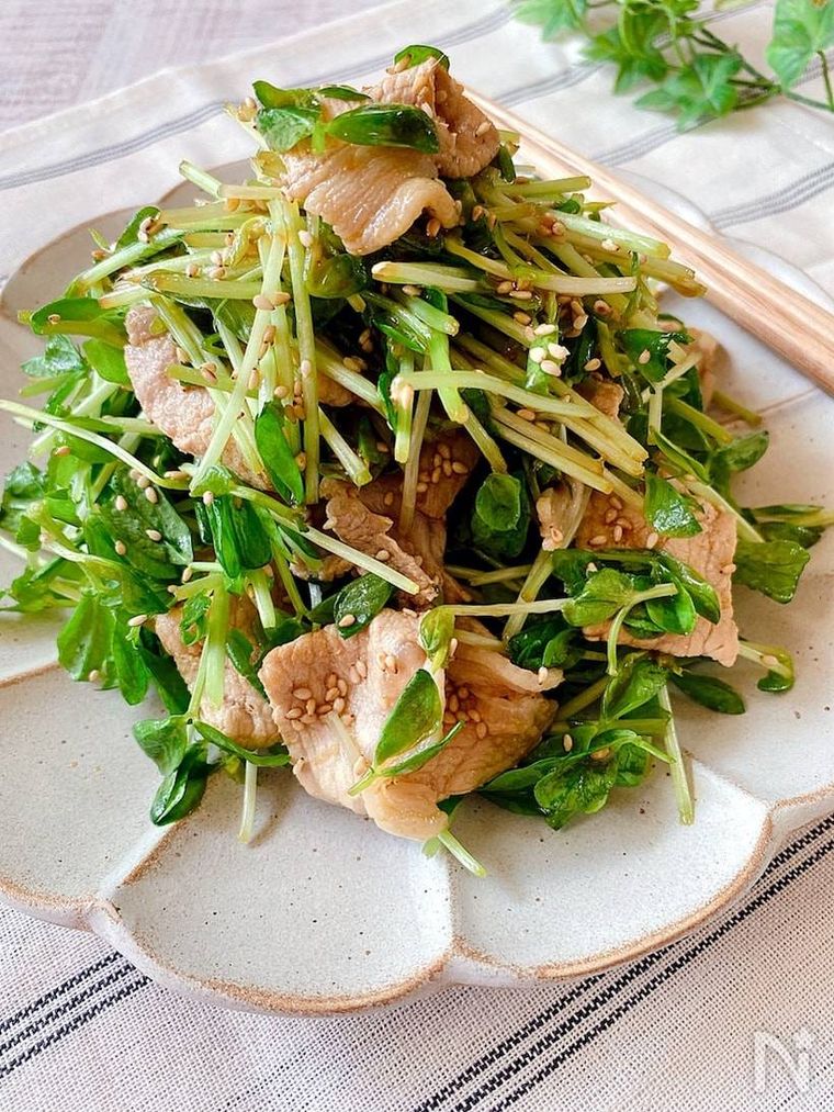 スカラップデザインの器に盛られた豆苗と豚肉の中華サラダ