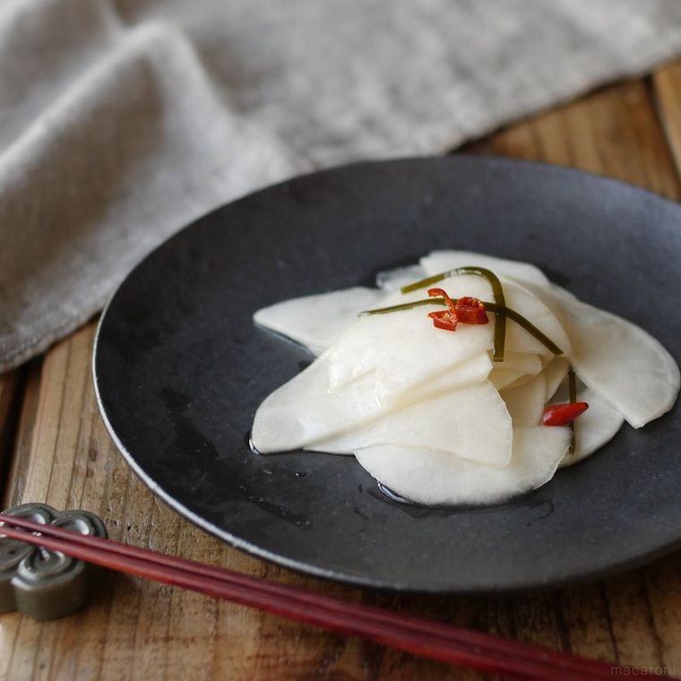 黒色の丸皿に盛られたかぶの千枚漬け