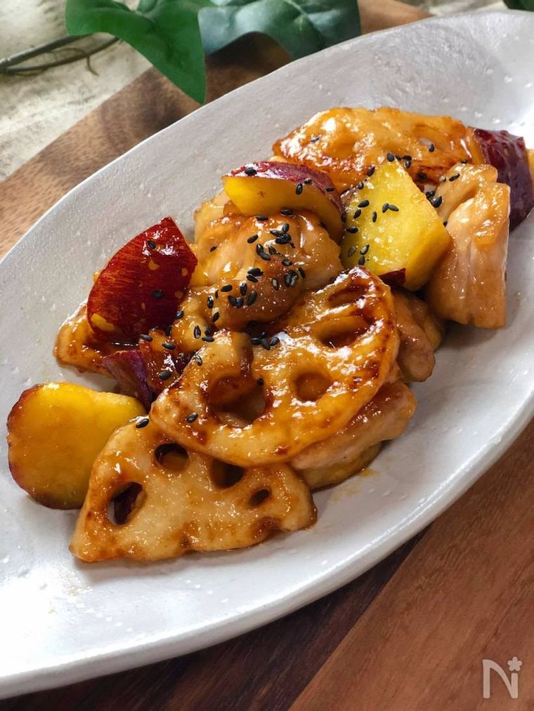 楕円形の白い器に盛られたさつまいもとれんこんと鶏肉の甘酢炒め