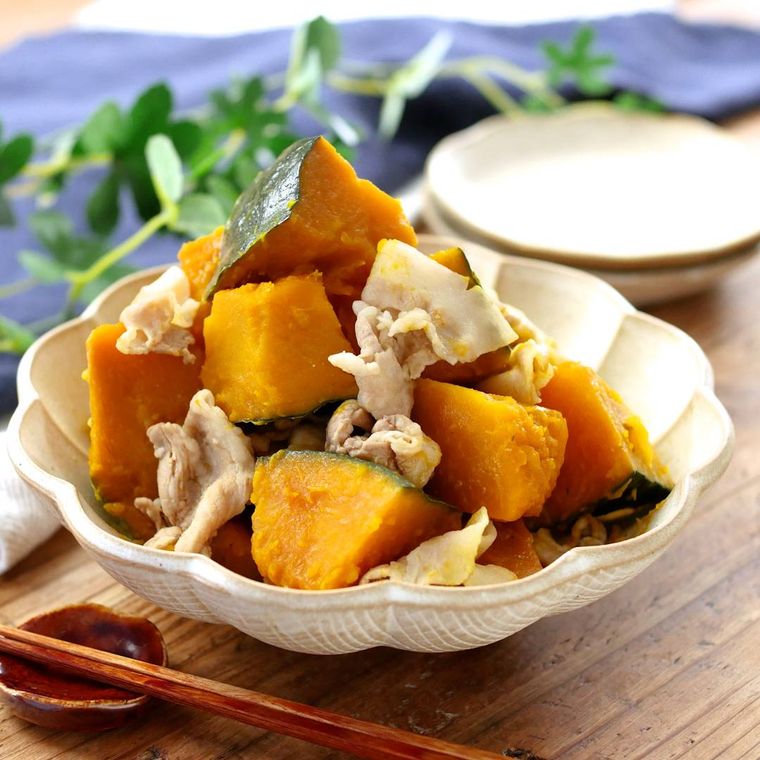 ベージュの鉢皿に入ったかぼちゃと豚肉の煮物