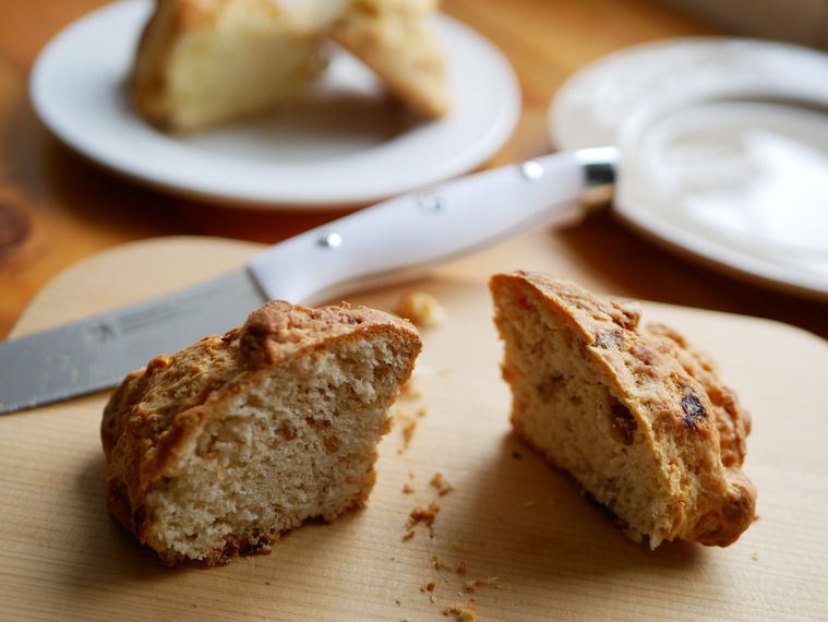 木のカッティングボードに置かれたコストコアイリッシュスコーンとナイフ