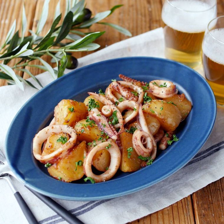 青い楕円皿に入ったイカとじゃがいものガリバタ炒め