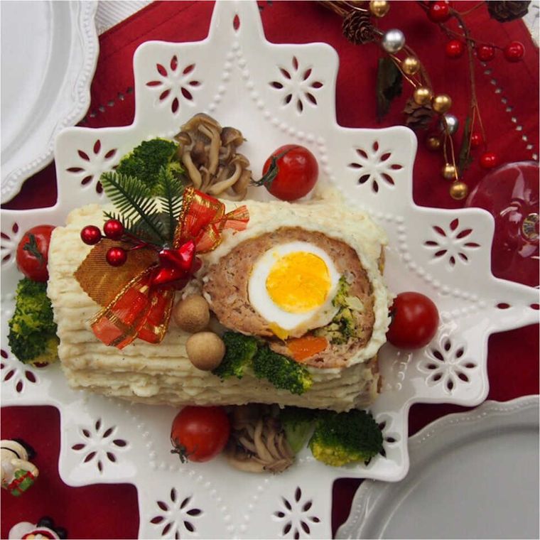 白いツリー型の皿に盛られた、切り株たまごの白いミートローフ