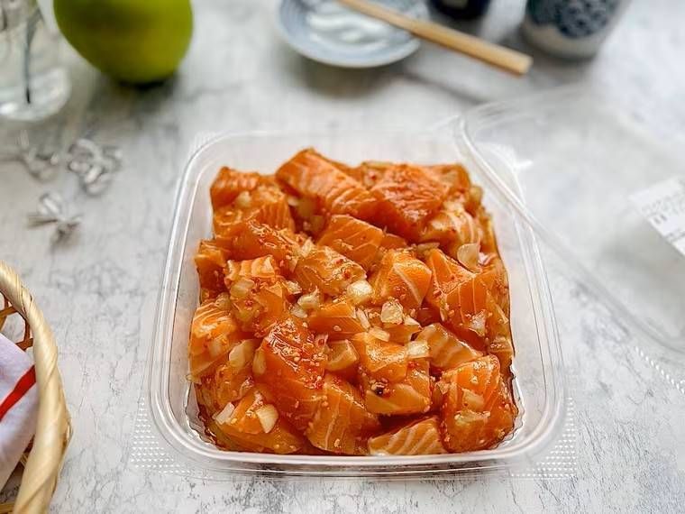 大理石調のテーブルの上にハワイアンサーモンポキが蓋を外され置かれている