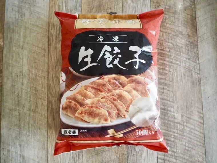 木目のテーブルに置かれた冷凍生餃子のパッケージ
