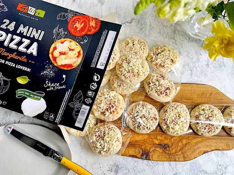 木製のプレートの上に、トレイに入ったミニピザが拡げられている様子